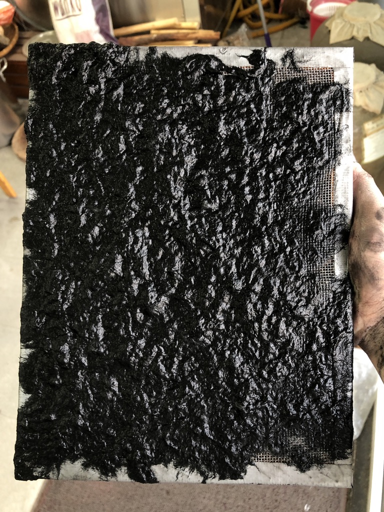 gather the black pulp on the paper making net
