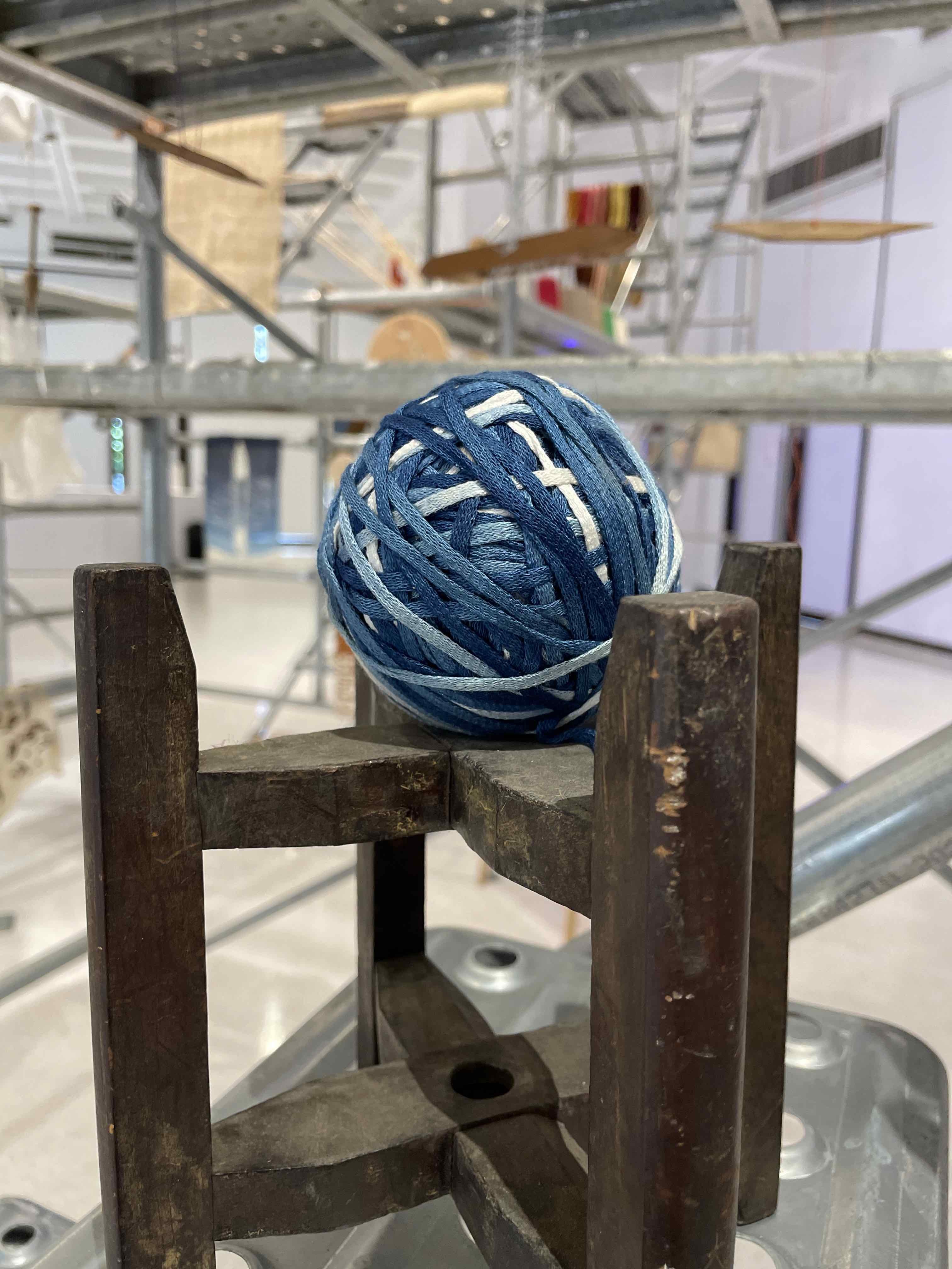 Winding wooden frame and thread ball: left/blue dyed bamboo fiber webbing, right/hemp hand-spun thread